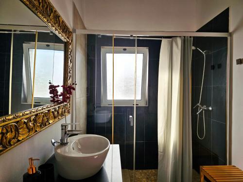 a bathroom with a sink and a mirror and a shower at Casa Cernicalo in Nazaret