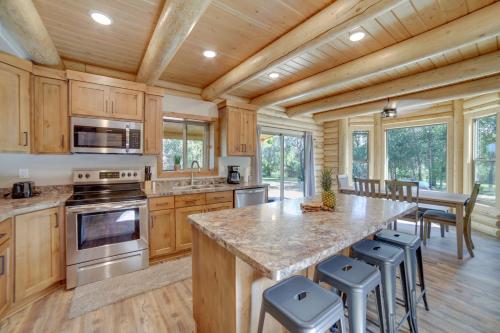 eine Küche mit Holzschränken und eine große Insel mit Barhockern in der Unterkunft Private Riverside Cabin, Golf Across the Street in Lorenzo