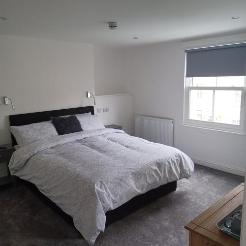 Un dormitorio blanco con una cama grande y una ventana en Premier house, en Whitby