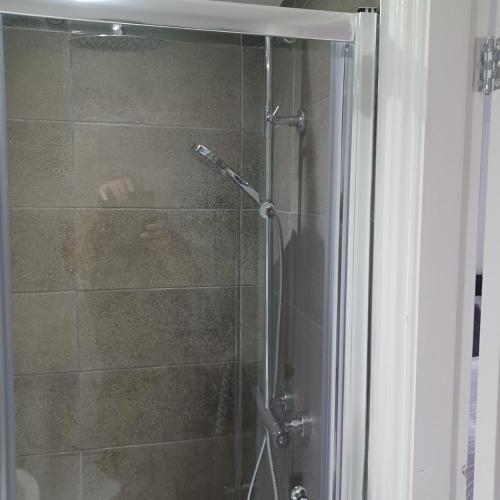 a shower with a glass door in a bathroom at Premier house in Whitby