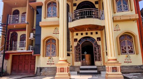 a building with red doors and balconies on it at Hotel Garuda in Rambah