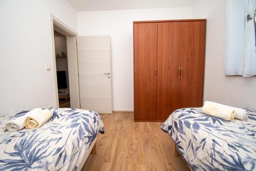 a bedroom with two beds and a wooden cabinet at Villa Afrodita in Pula-Istrien in Pula