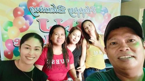 a group of women standing in front of a sign with balloons at BNJ Boarding House in Bislig