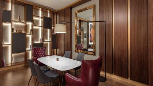 a dining room with a table and chairs and a mirror at Hilton Istanbul Maslak in Istanbul