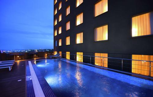 a building with a swimming pool in front of a building at Hilton Garden Inn Kampala in Kampala