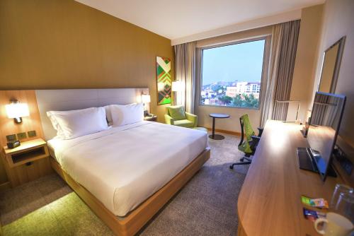 a hotel room with a large bed and a window at Hilton Garden Inn Kampala in Kampala