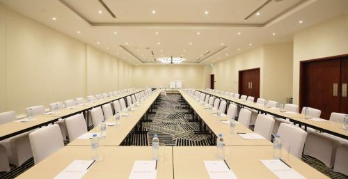 a large room with long tables and white chairs at Hilton Garden Inn Kampala in Kampala