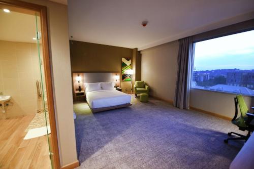 a hotel room with a bed and a large window at Hilton Garden Inn Kampala in Kampala