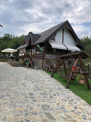 a building with a pavilion with a cobblestone walkway at La Foisor in Vărbilău