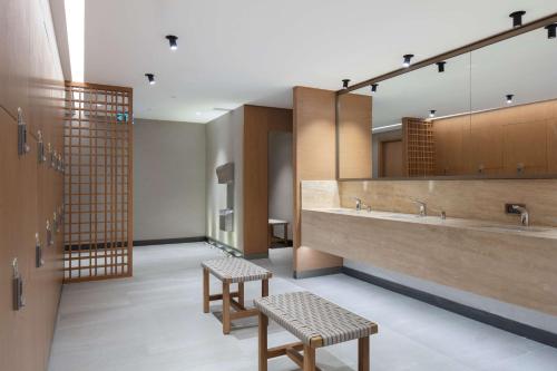- une grande salle de bains avec deux lavabos et deux tabourets dans l'établissement Doubletree By Hilton Canakkale, à Çanakkale