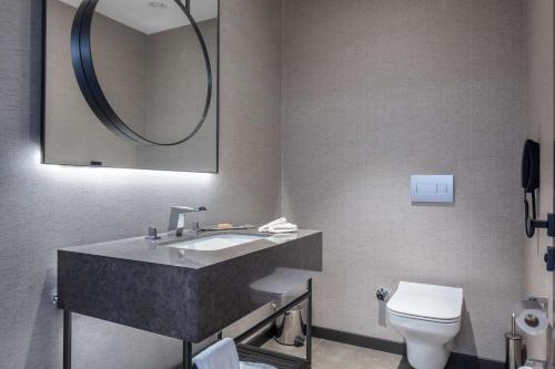 a bathroom with a sink and a toilet and a mirror at Doubletree By Hilton Canakkale in Canakkale