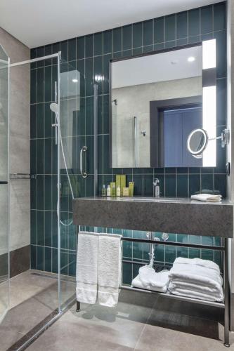 a bathroom with a shower and a sink and a mirror at Doubletree By Hilton Canakkale in Canakkale