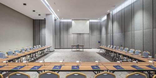 a conference room with tables and chairs and a screen at Doubletree By Hilton Canakkale in Canakkale