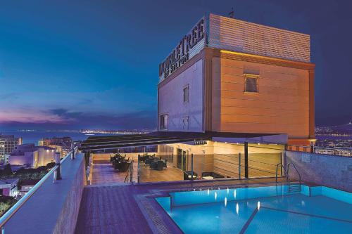 a building with a swimming pool on top of a building at DoubleTree by Hilton Izmir - Alsancak in İzmir