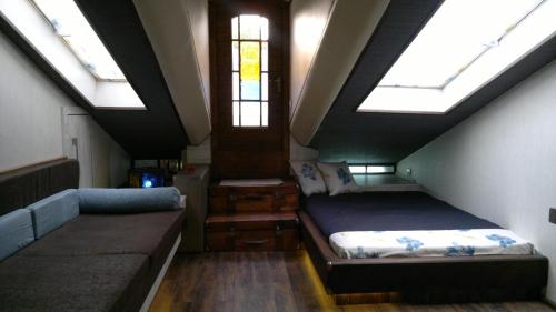 een zolderkamer met 2 bedden en dakramen bij Hotel Imaginarium in Tbilisi City