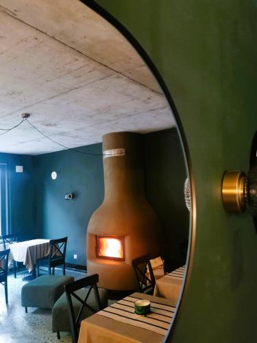 a mirror reflecting a room with a table and a fireplace at Pin Boutique Hotel in Dealu Frumos