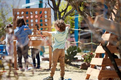 two children playing with a bow and arrow in a playground at Casa Pavo Real en el Viñedo El Pavo Real del Campo in San Miguel de Allende
