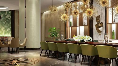 a dining room with a table and green chairs at Hilton Mall Of Istanbul in Istanbul