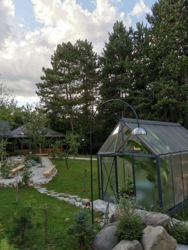 a greenhouse in a garden with a street light at Pin Boutique Hotel in Dealu Frumos