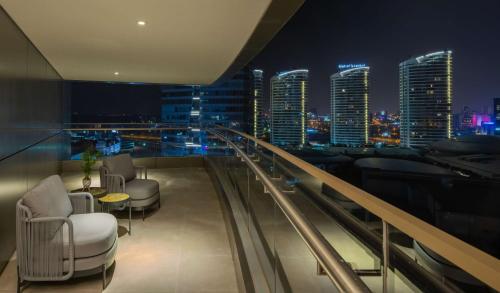 a balcony with chairs and a city skyline at night at Hilton Mall Of Istanbul in Istanbul