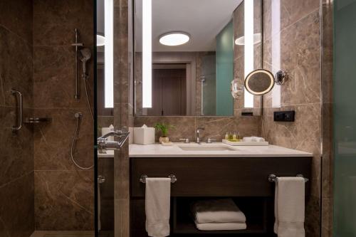 a bathroom with a sink and a shower with a mirror at Hilton Mall Of Istanbul in Istanbul
