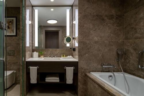 a bathroom with a tub and a sink and a bath tub at Hilton Mall Of Istanbul in Istanbul