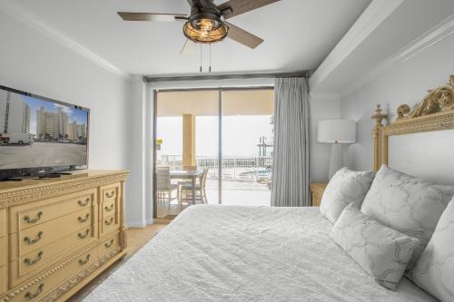 a bedroom with a bed and a flat screen tv at Summer House 103A by Vacation Homes Collection in Orange Beach