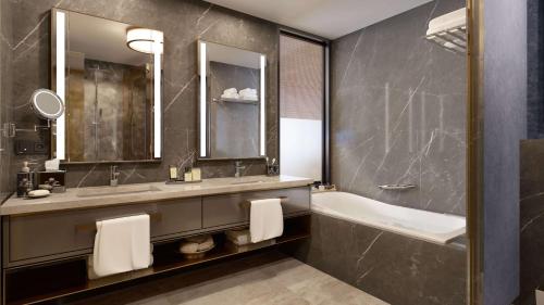 a bathroom with a tub and a sink and a tub and a mirror at Hilton Mall Of Istanbul in Istanbul