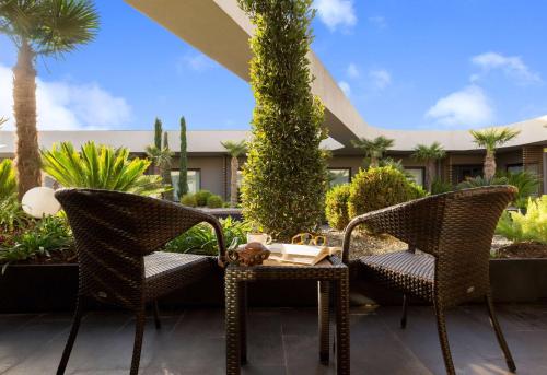 two wicker chairs and a table on a patio at DoubleTree By Hilton Izmir Airport in Izmir