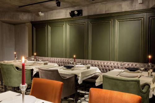a dining room with tables and chairs with candles at DoubleTree By Hilton Izmir Airport in Izmir