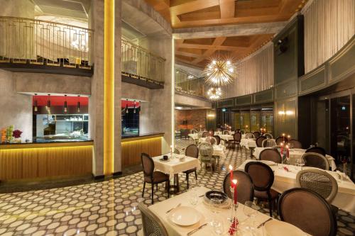 دوبل تري باي هيلتون إزمير إيربورت في إزمير: غرفة طعام مع طاولات وكراسي ومطعم
