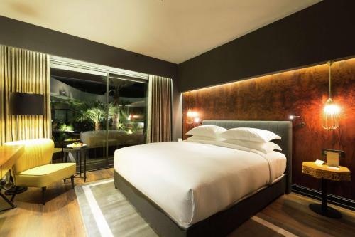 a bedroom with a large white bed and a desk at DoubleTree By Hilton Izmir Airport in Izmir