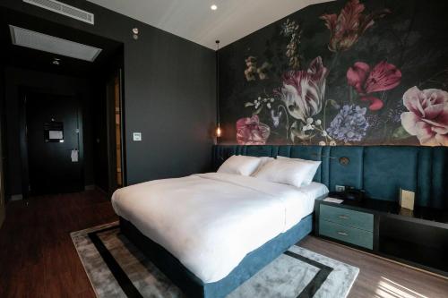 a bedroom with a large bed with a painting on the wall at DoubleTree By Hilton Izmir Airport in Izmir