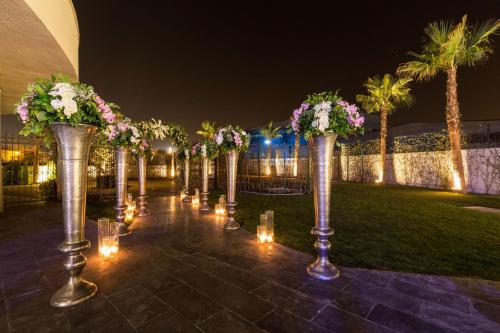 a row of silver vases with flowers and lights at DoubleTree By Hilton Izmir Airport in Izmir