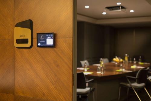 a conference room with a table and a door with a clock at DoubleTree By Hilton Izmir Airport in Izmir