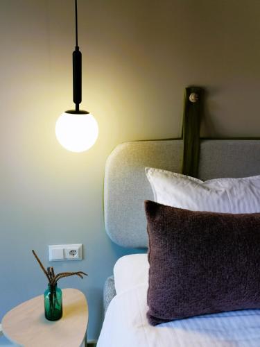 a bedroom with a bed with a table and a lamp at Pin Boutique Hotel in Dealu Frumos