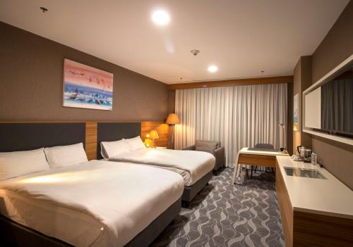 a hotel room with two beds and a desk at DoubleTree by Hilton Ankara Incek in Ankara
