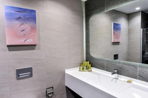 y baño con lavabo blanco y espejo. en DoubleTree by Hilton Ankara Incek, en Ankara