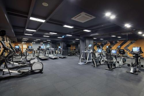 a gym with several treadmills and cardio machines at Doubletree By Hilton Antalya City Centre in Antalya
