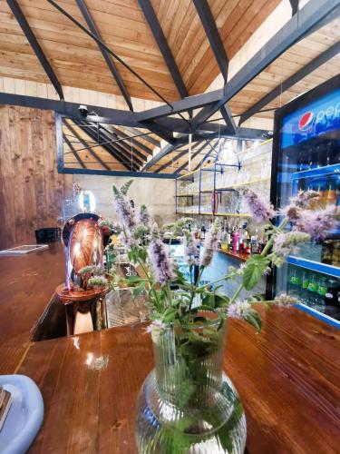 a vase with flowers on a table in a bar at Pin Boutique Hotel in Dealu Frumos