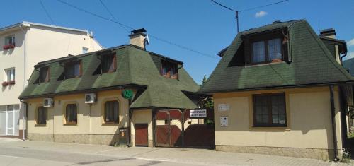 a building with a green roof on a street at Penzión Weinerovka Varín in Žilina