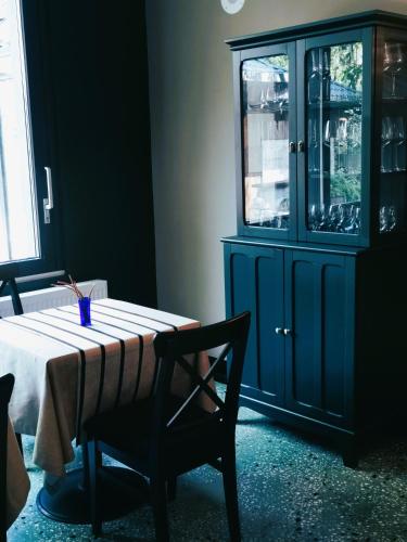 a dining room table with a chair and a blue cabinet at Pin Boutique Hotel in Dealu Frumos