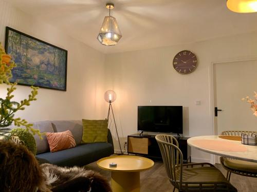 a living room with a couch and a tv at Rode Bosuil: thuiskomen op De Veluwe! in Otterlo