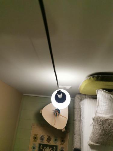 a light hanging from a ceiling with a surfboard on a bed at Pin Boutique Hotel in Dealu Frumos