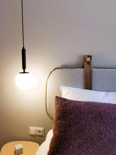 a bedroom with a bed with a purple pillow and a lamp at Pin Boutique Hotel in Dealu Frumos
