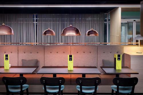 a row of tables and chairs in a room with lights at Hampton By Hilton Bristol Airport in Redhill