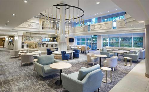 a lobby with tables and chairs and a chandelier at Hilton London Croydon in Croydon