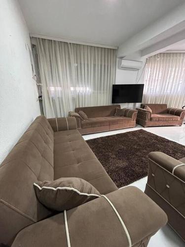 a living room with a couch and a tv at Cozy Corner Apartment in Gjakove