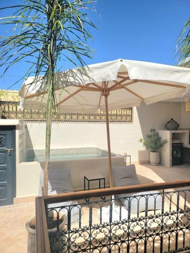 patio z parasolem i stołem w obiekcie Riad Isahiac avec piscine en exclusivité w Marakeszu