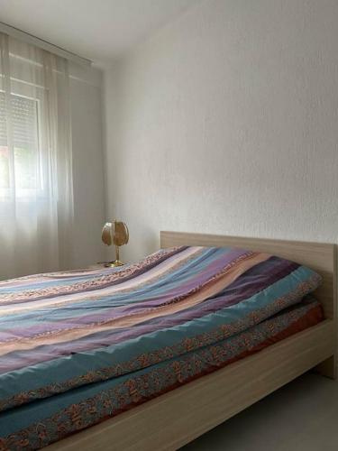 a bed with a wooden frame in a bedroom at Cozy Corner Apartment in Gjakove